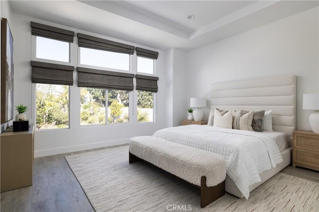 bedroom featuring recessed lighting, baseboards, multiple windows, and light wood-style flooring