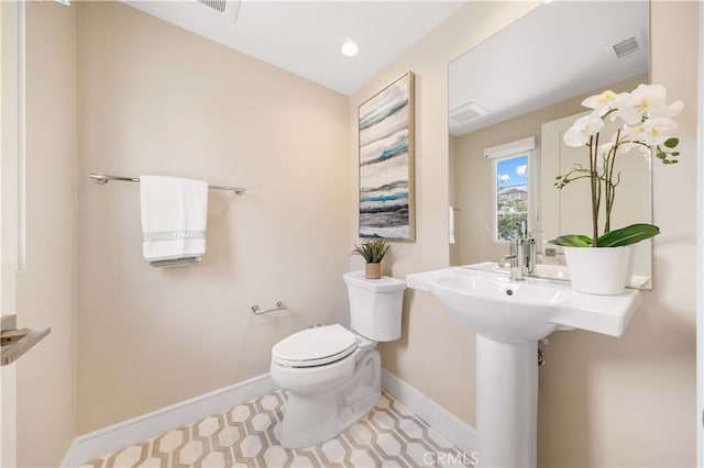 bathroom with visible vents, toilet, and baseboards