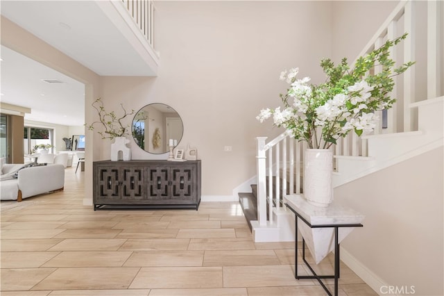 foyer entrance with stairway, baseboards, and wood tiled floor