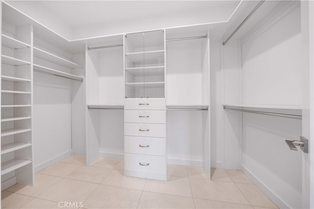 walk in closet with light tile patterned floors