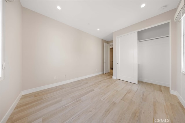 unfurnished bedroom with recessed lighting, light wood-type flooring, and baseboards