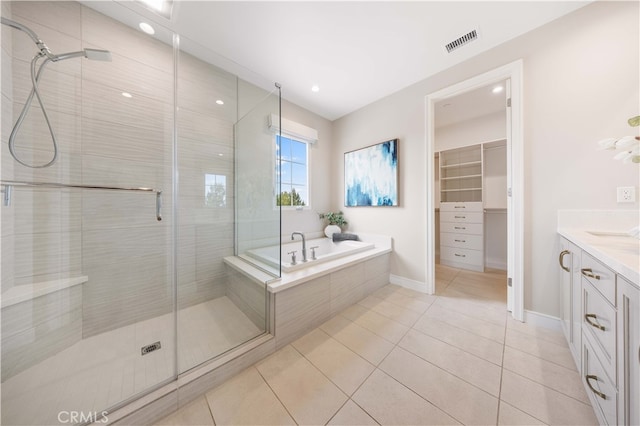 bathroom featuring tile patterned flooring, visible vents, a shower stall, a bath, and vanity