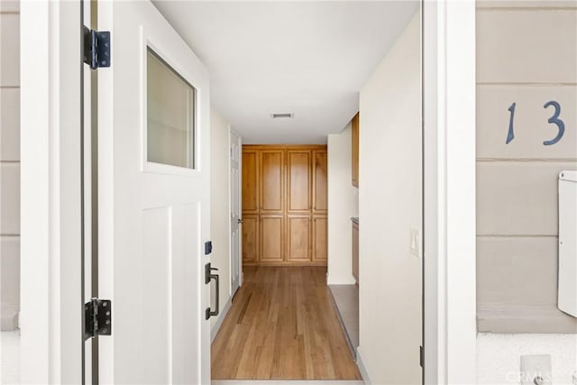 hallway featuring visible vents and light wood finished floors