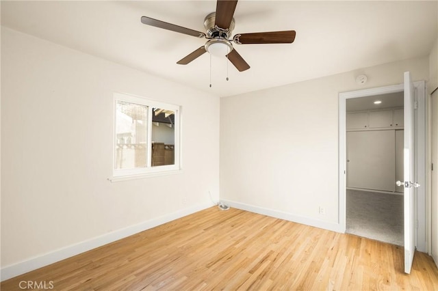 unfurnished bedroom featuring a closet, baseboards, a ceiling fan, and light wood finished floors