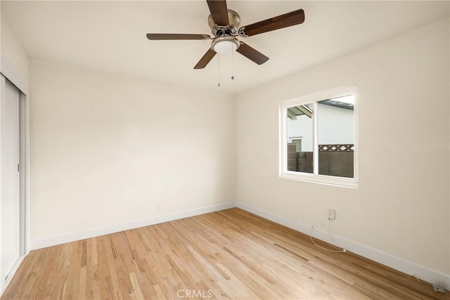 unfurnished room featuring baseboards, ceiling fan, and light wood finished floors