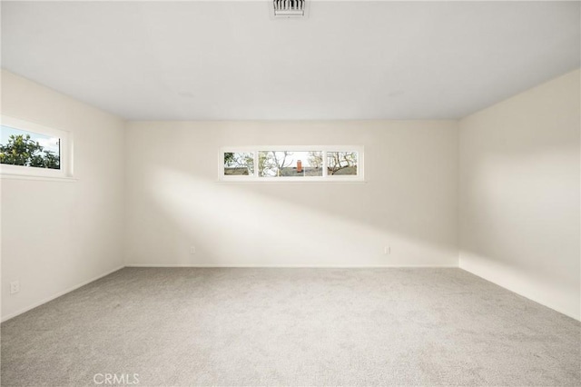 empty room featuring visible vents and carpet flooring