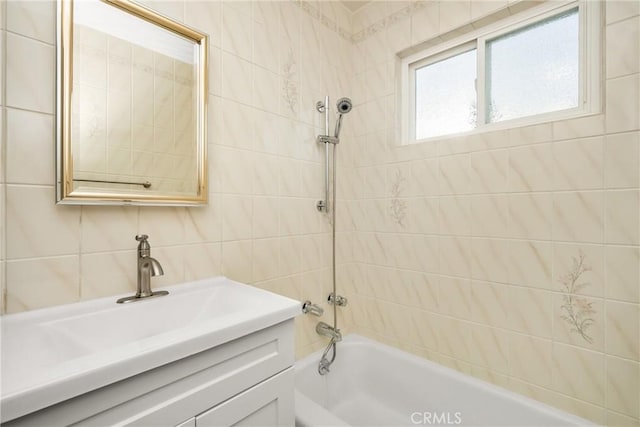 bathroom featuring vanity, tile walls, tub / shower combination, and decorative backsplash