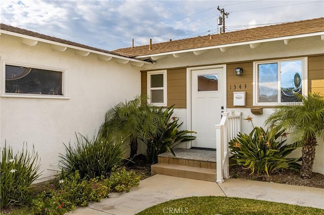 doorway to property featuring stucco siding