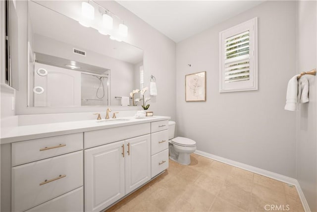 bathroom featuring vanity, baseboards, visible vents, toilet, and a shower with door