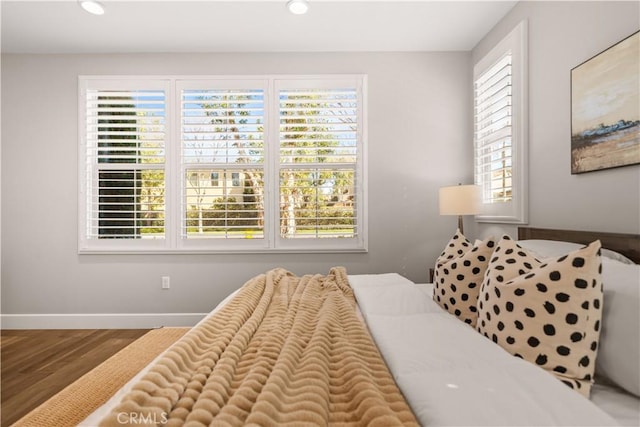 bedroom featuring recessed lighting, multiple windows, baseboards, and wood finished floors