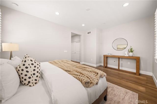 bedroom with recessed lighting, visible vents, baseboards, and wood finished floors