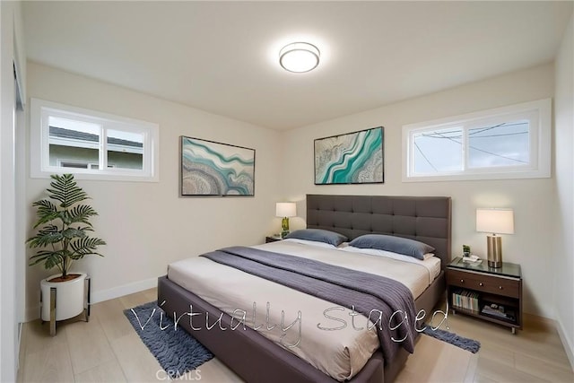 bedroom featuring baseboards and light wood finished floors