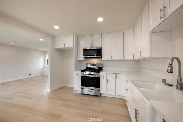 kitchen with white cabinetry, recessed lighting, appliances with stainless steel finishes, and a sink