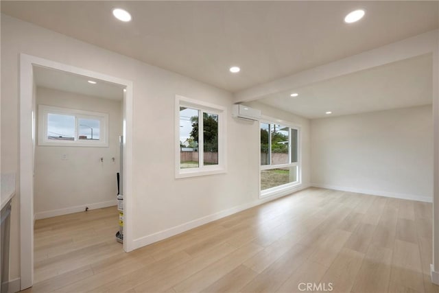 spare room featuring recessed lighting, light wood-type flooring, and a wall unit AC