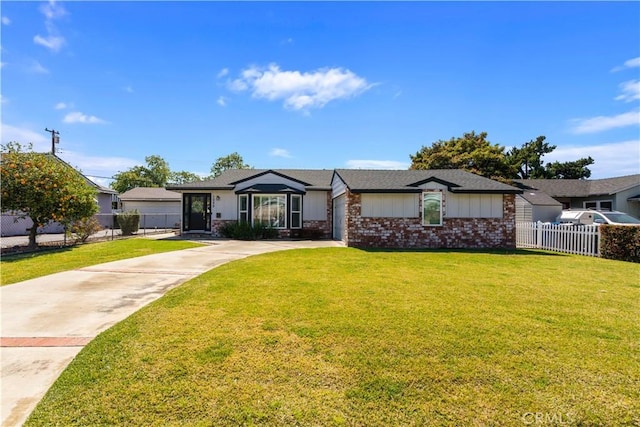 view of front of property with a front lawn, fence, brick siding, and driveway