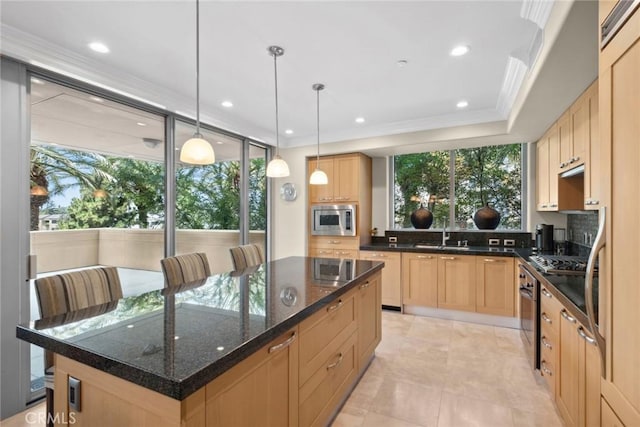 kitchen with a kitchen island, a sink, light brown cabinetry, appliances with stainless steel finishes, and a raised ceiling