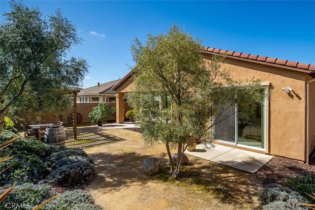 back of house with stucco siding, fence, and a patio area