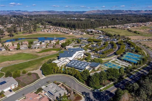 drone / aerial view with a water and mountain view and view of golf course