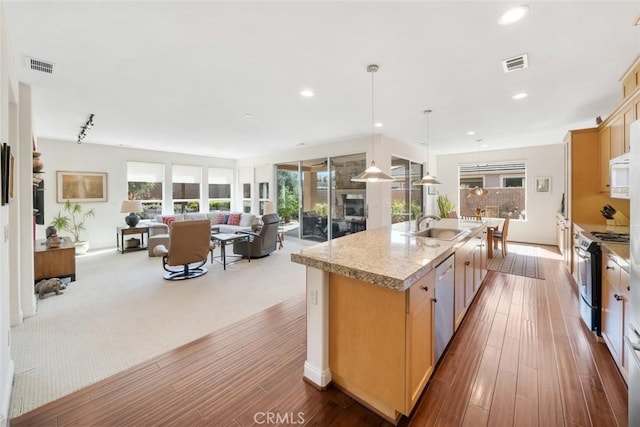 kitchen with a kitchen island with sink, visible vents, appliances with stainless steel finishes, and open floor plan