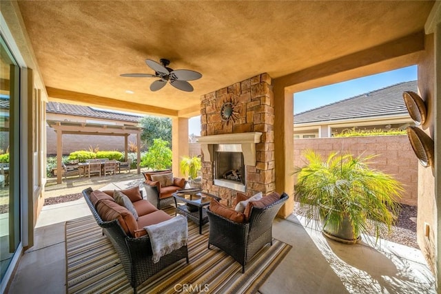 view of patio / terrace featuring fence, ceiling fan, and an outdoor living space with a fireplace