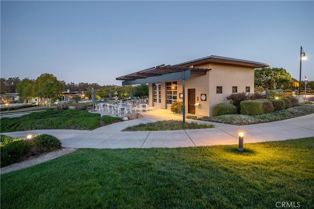 exterior space with a patio area, stucco siding, and a yard