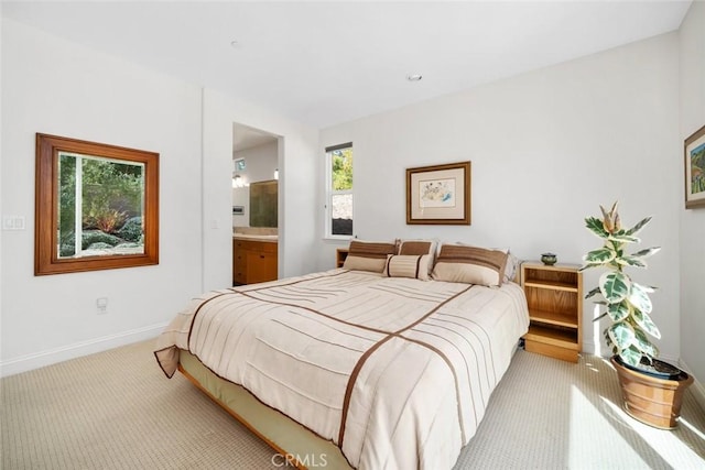 carpeted bedroom with baseboards and ensuite bathroom