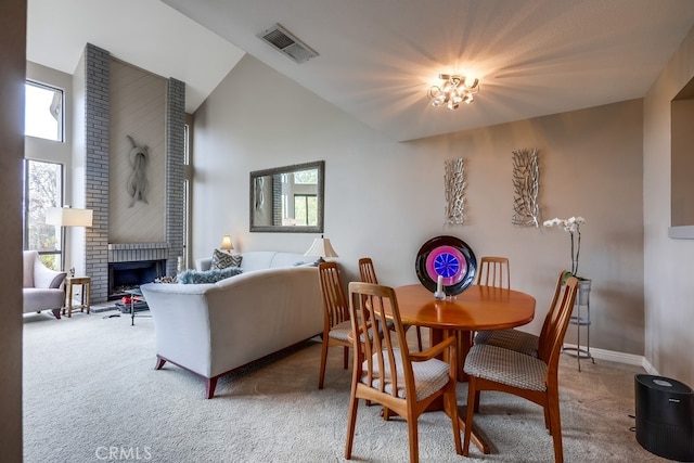 dining space with carpet flooring, visible vents, a wealth of natural light, and high vaulted ceiling