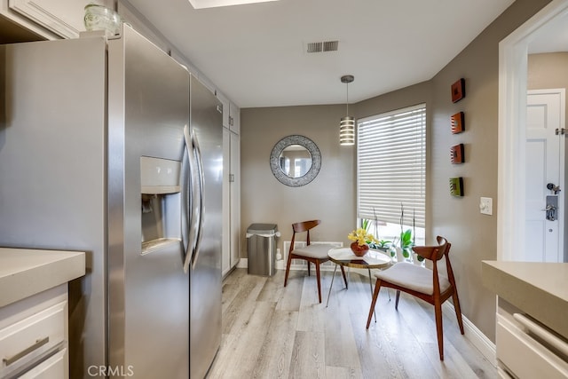 living area featuring visible vents, plenty of natural light, baseboards, and light wood-style flooring