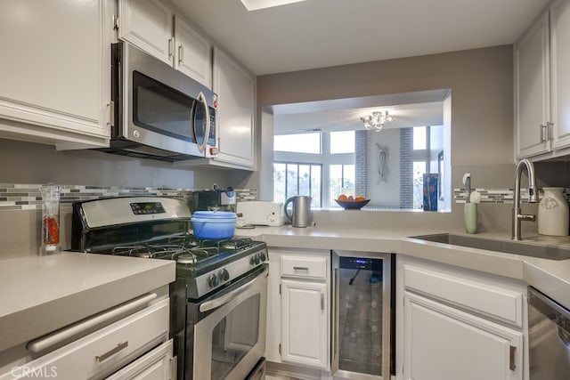 27578 Lene, Mission Viejo, CA 92692 - kitchen featuring appliances with stainless steel finishes, beverage cooler, a sink, light countertops, and white cabinetry