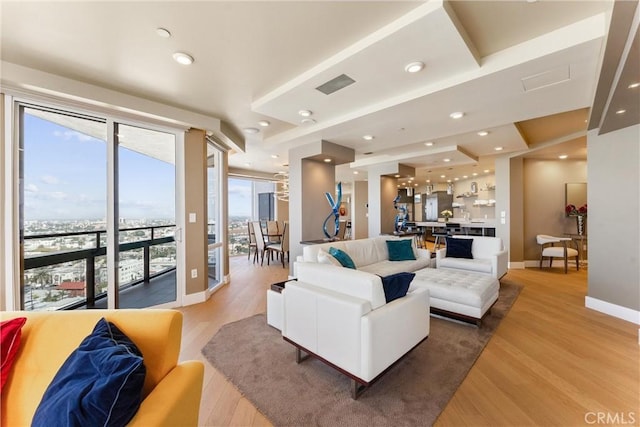 living area with light wood-style flooring, recessed lighting, visible vents, and baseboards