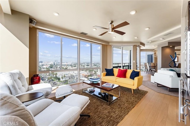 living room with visible vents, a view of city, recessed lighting, light wood finished floors, and ceiling fan