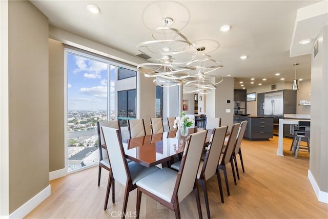 dining space featuring light wood-type flooring, visible vents, recessed lighting, an inviting chandelier, and baseboards