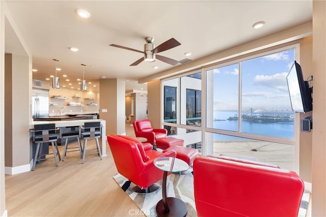 living room featuring a ceiling fan, recessed lighting, light wood-style floors, and baseboards