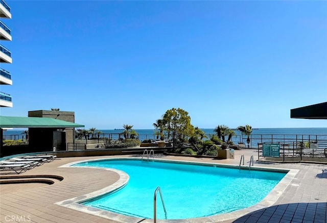 pool with a patio and a water view