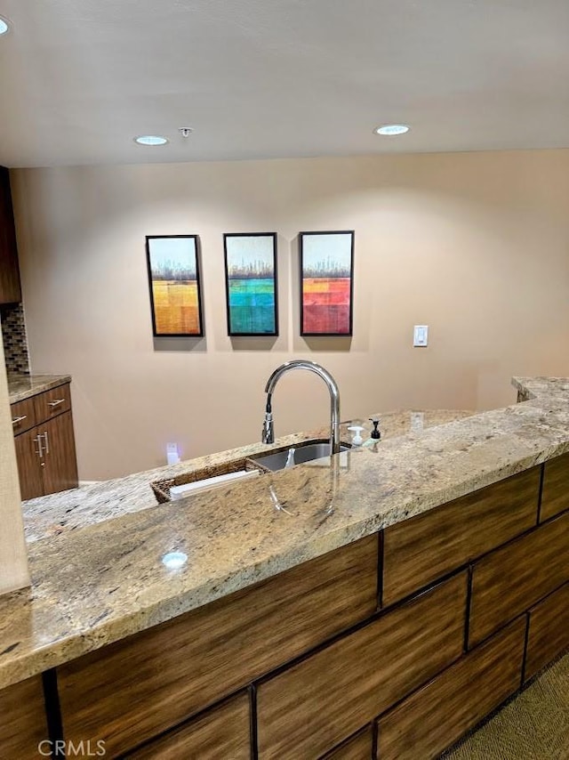 kitchen with light stone counters and recessed lighting