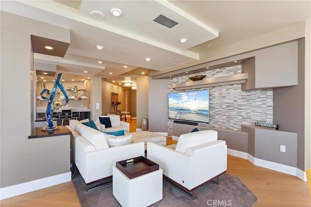 living area with recessed lighting, light wood-style floors, and baseboards