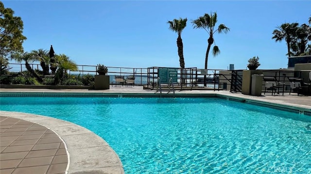 pool with a patio and fence