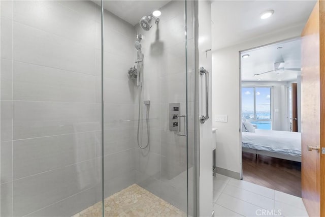 bathroom featuring tile patterned floors, baseboards, ensuite bath, and a shower stall