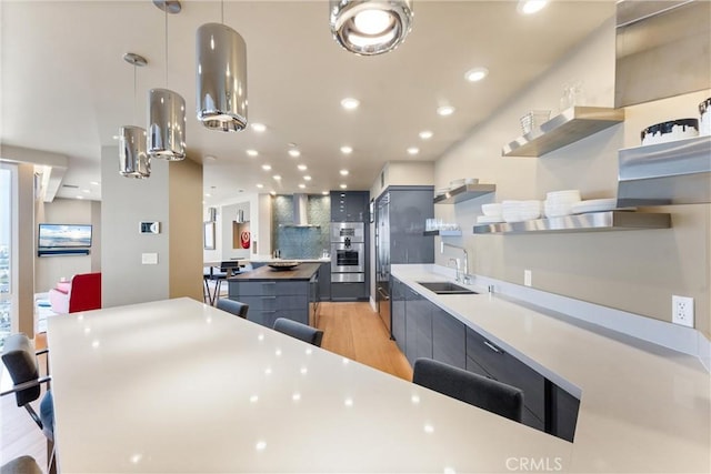 kitchen with a kitchen island, open shelves, light wood-style flooring, wall chimney exhaust hood, and backsplash