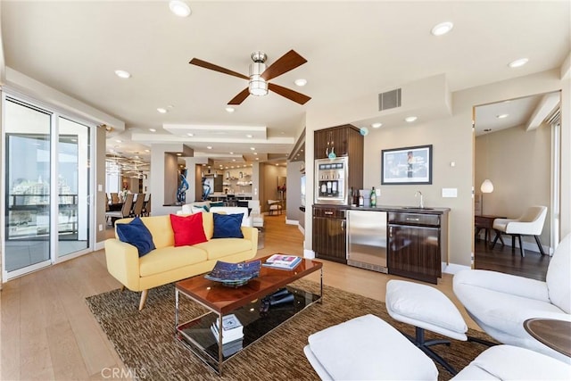 living area featuring recessed lighting, indoor wet bar, visible vents, and light wood-style flooring