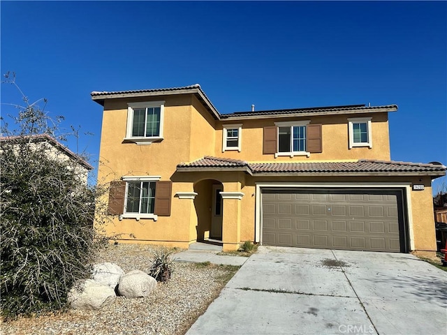 mediterranean / spanish home with a tiled roof, stucco siding, driveway, and an attached garage