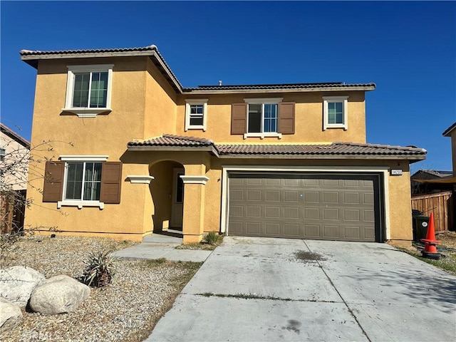 mediterranean / spanish-style home with stucco siding, an attached garage, driveway, and a tile roof