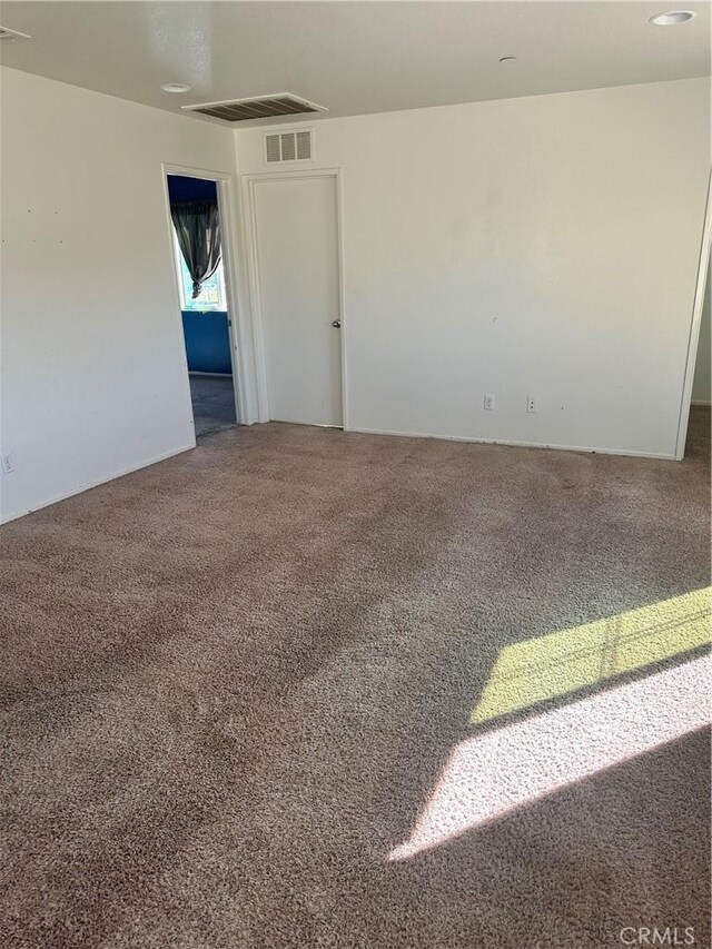 carpeted empty room with visible vents