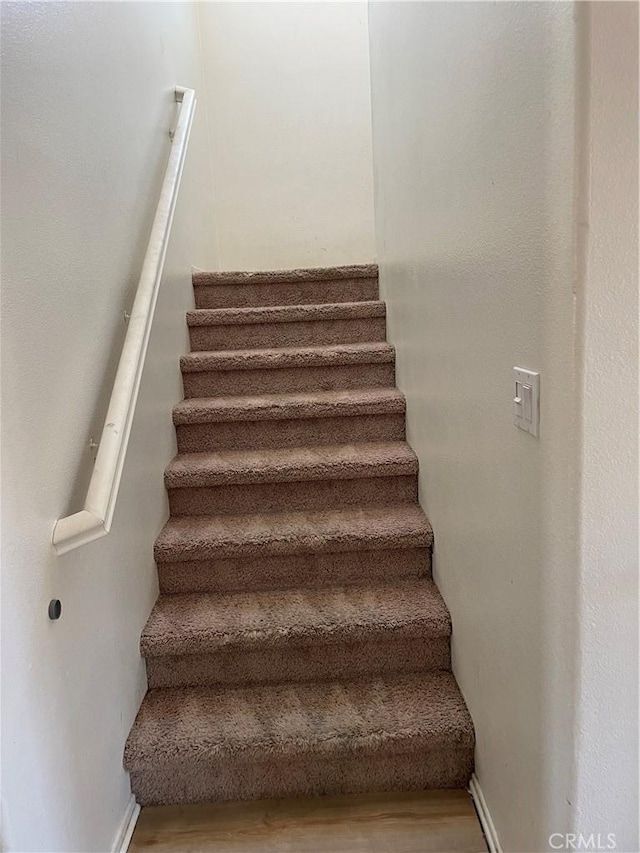 stairs featuring baseboards and wood finished floors