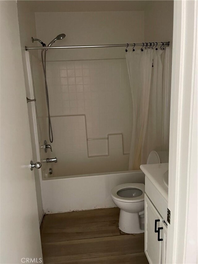 full bath with toilet, wood finished floors, vanity, and shower / bath combination with curtain