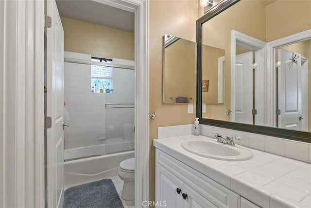 bathroom with vanity, toilet, and combined bath / shower with glass door