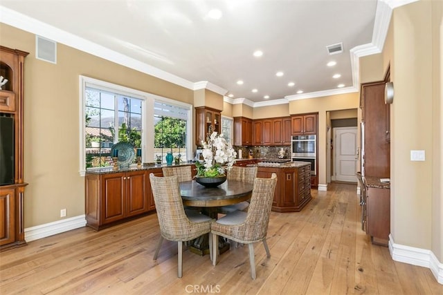 dining room featuring light wood finished floors, visible vents, baseboards, ornamental molding, and recessed lighting