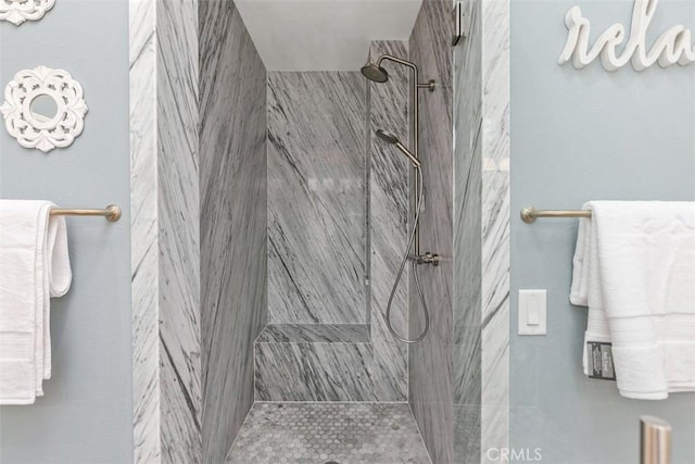 bathroom featuring a marble finish shower