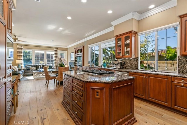 kitchen featuring decorative backsplash, open floor plan, appliances with stainless steel finishes, and a sink