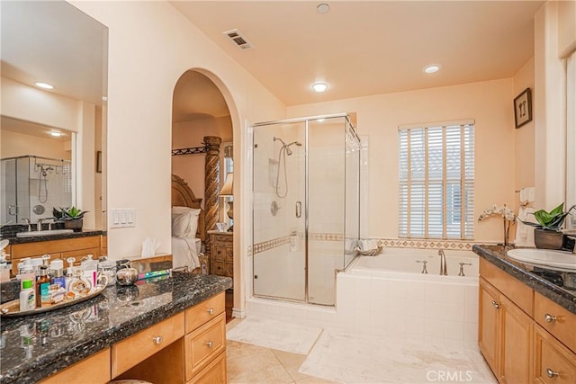 bathroom featuring tile patterned flooring, a shower stall, visible vents, and a sink